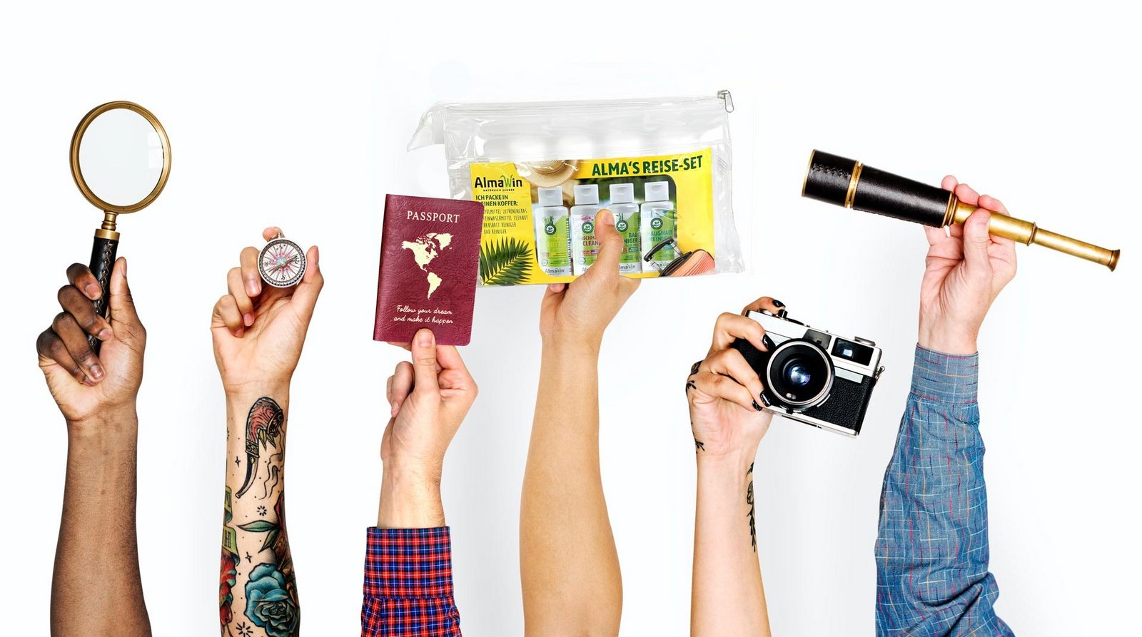 Hände recken Urlaubsutensilien und das Alma's Reise Set in die Höhe