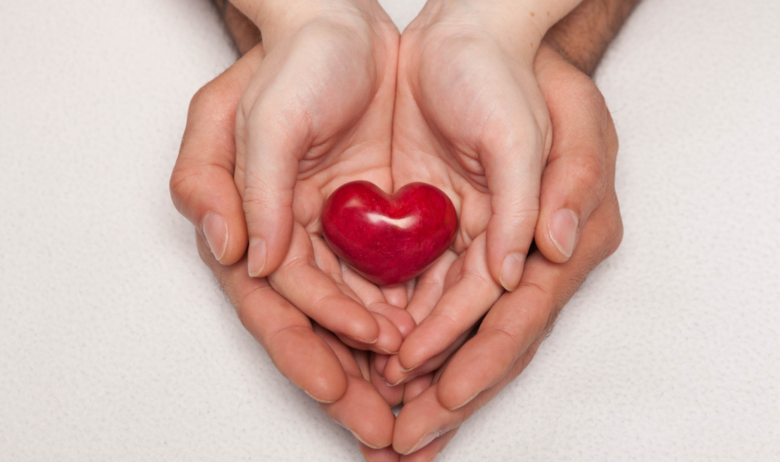 Symbolic image: 2 hands lie in each other and hold heart