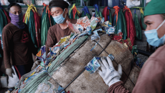 Clean Hub Press Picture 3 Men carrying a bundle of collected plastic waste