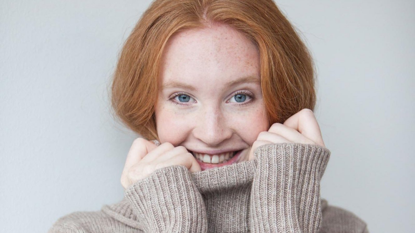 Young woman with red hair wearing a turtleneck sweater